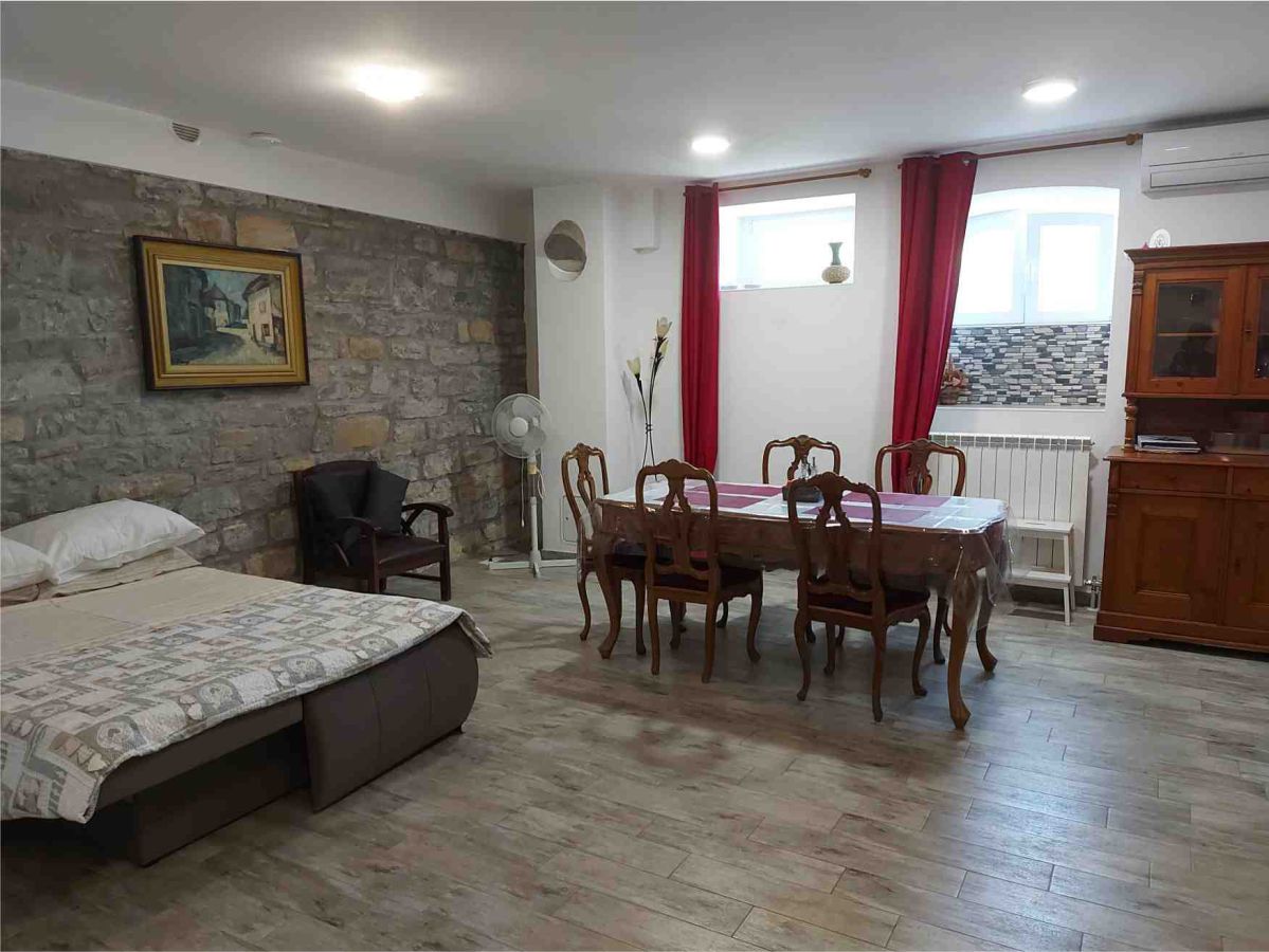 living room with window, table, chairs, bed sofa, windows