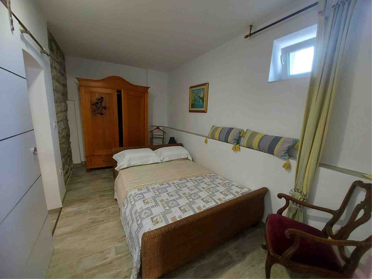 ein Zimmer mit Bett, Kleiderschrank, Stuhl, Fenster