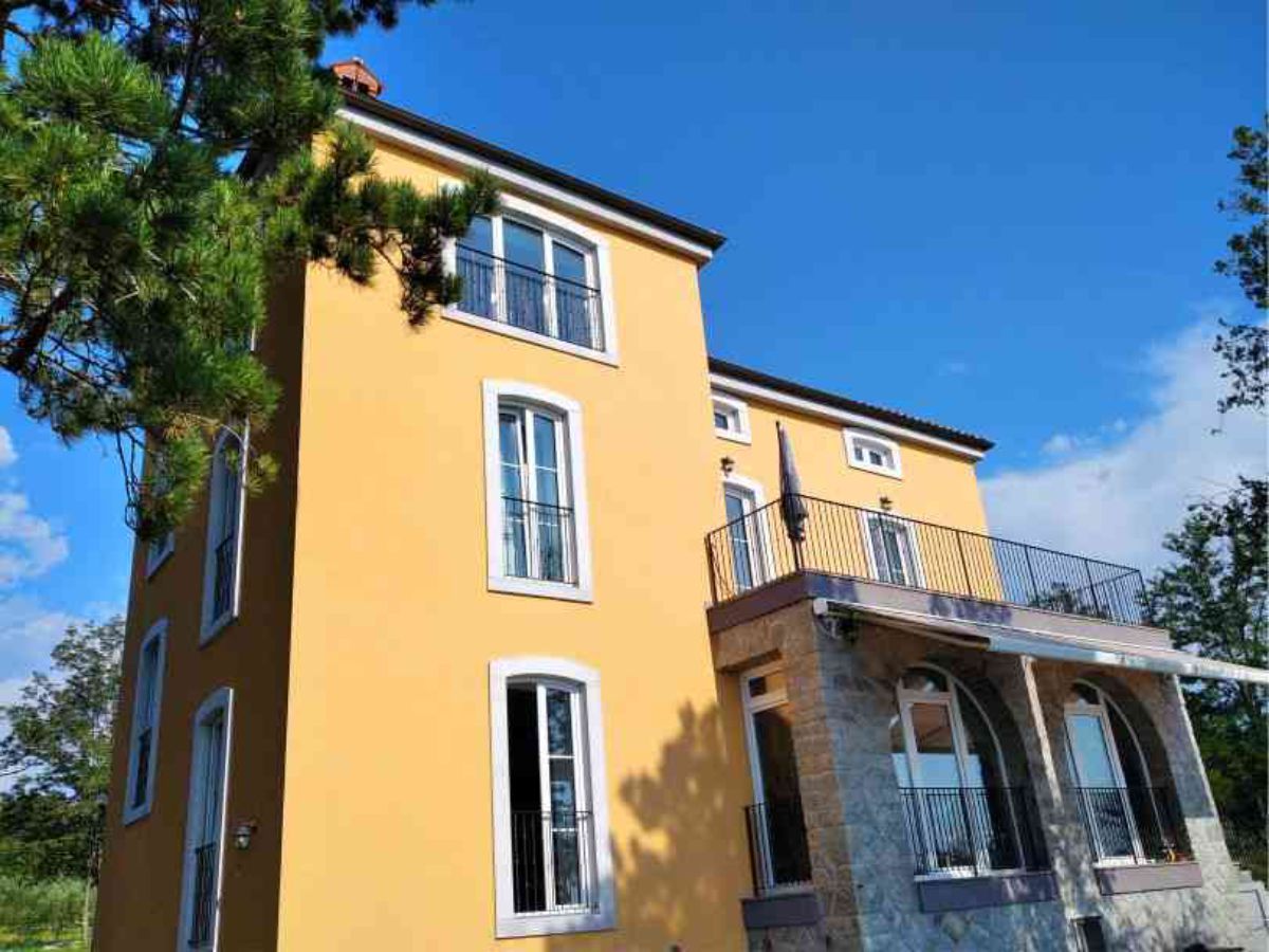 Una casa con finestre e una terrazza con una recinzione